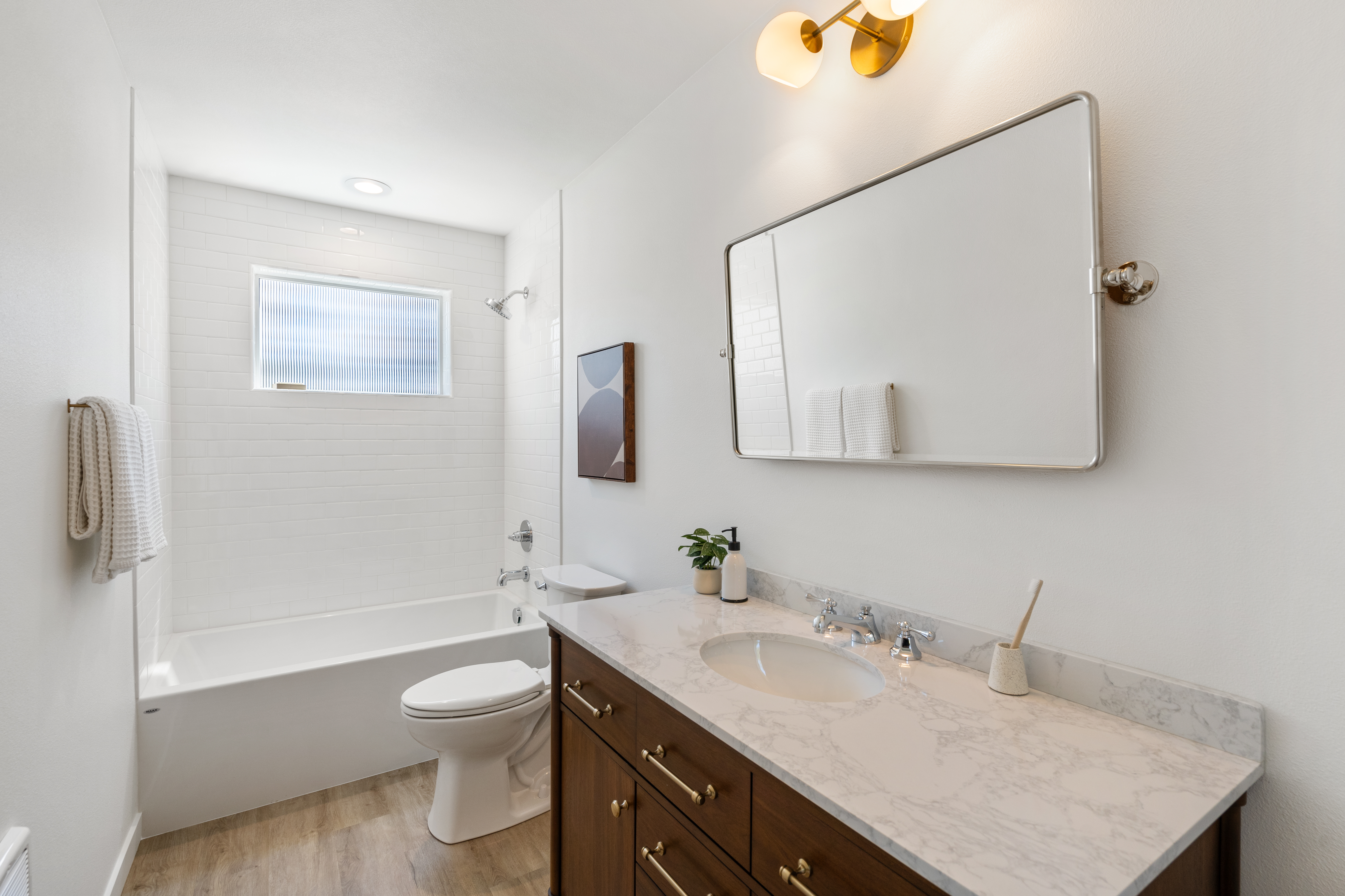 Bathroom with tub and dark wood vanity