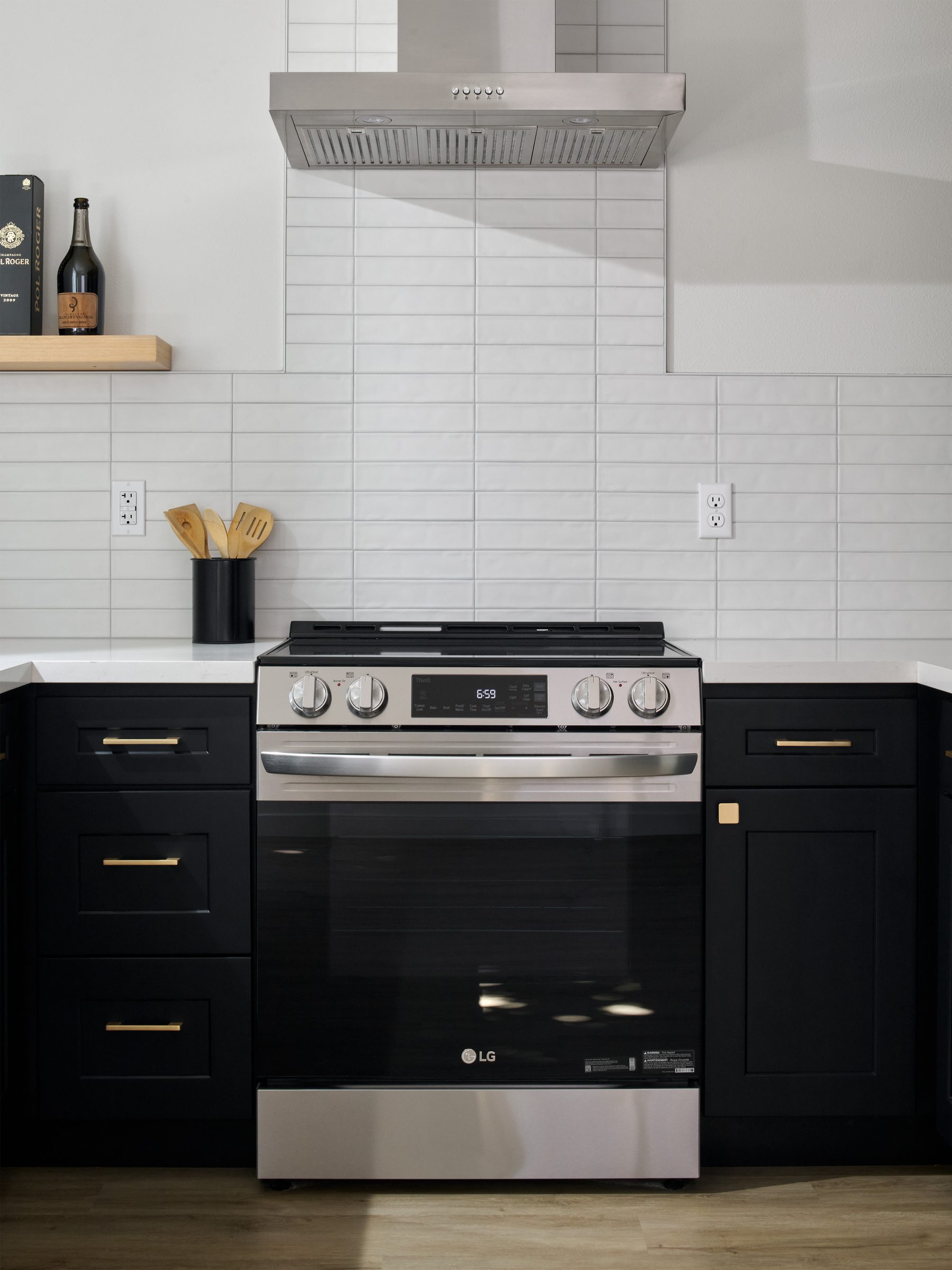 Kitchen range and hood with white subway-tile backsplash and floating shelf