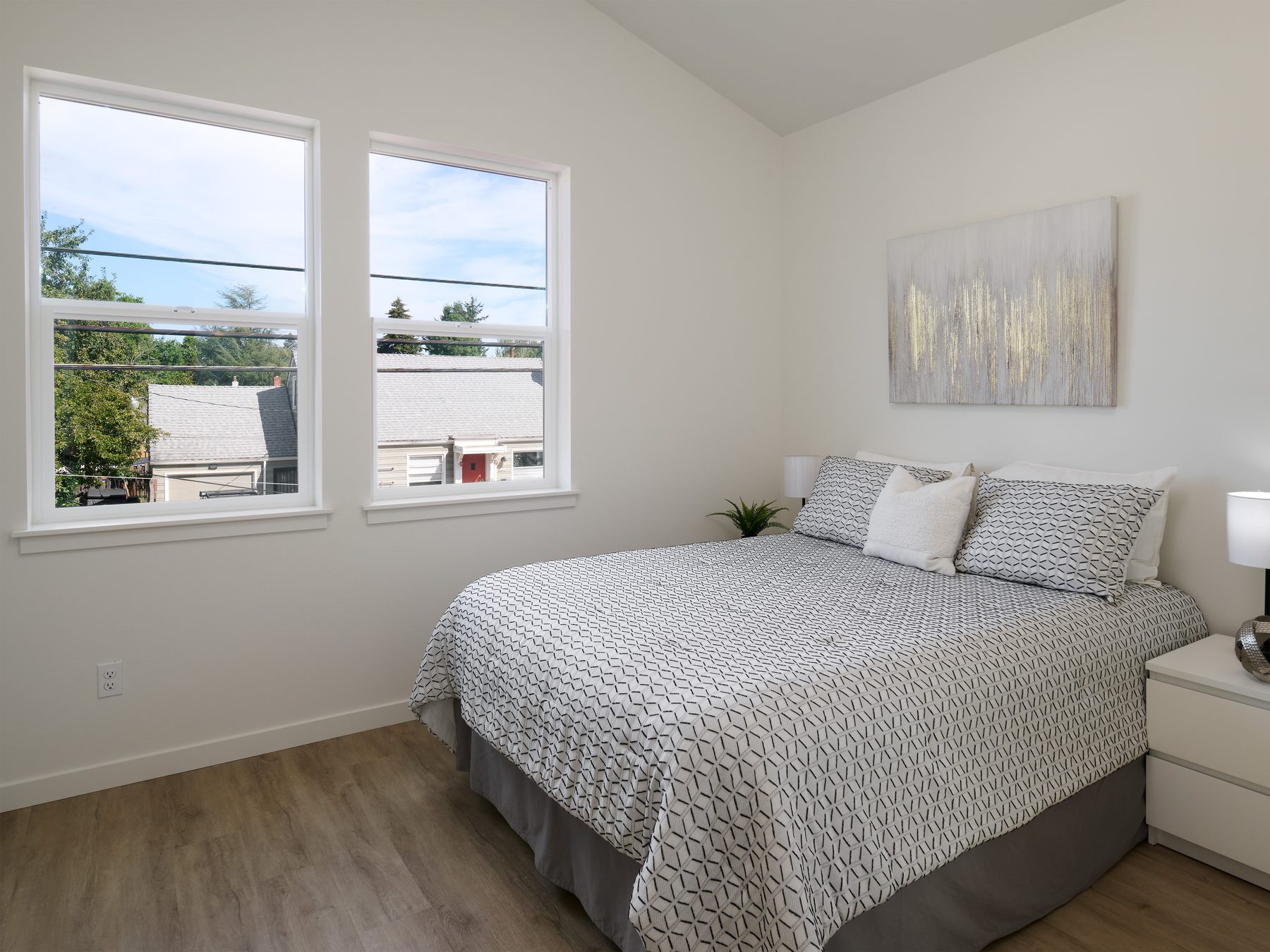 Airy bedroom with vaulted ceiling and windows overlooking the neighborhood